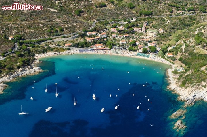 Immagine Veduta aerea della spiaggia di Cavoli, lungo la costa sud-occidentale dell'Isola d'Elba, situata tra Marina di Campo e la frazione di Seccheto. Lunga circa 300 m, di sabbia bianca e soffice interrotta al centro da scogli granitici, è tra le spiagge più amate e più frequentate dell'isola insieme a quella della Fetovaia. A sinistra della spiaggia, seguendo il litorale per circa 600 m, si arriva alla suggestiva Grotta Azzurra, visitabile in pedalò o con piccole imbarcazioni  - © stefano marinari / Shutterstock.com