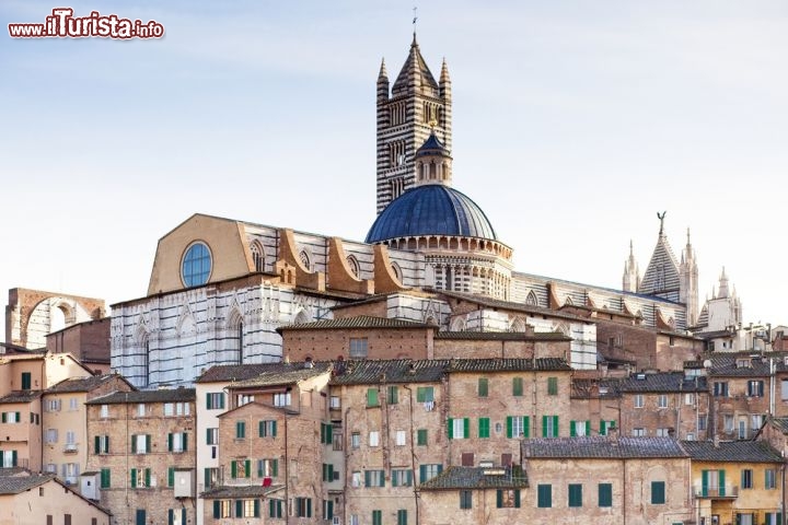 Immagine Palazzi nel centro di Siena, Toscana: le case di origine medievale si stringono intorno al Duomo di Santa Maria Assunta, che svetta su di loro con la sua cupola, il campanile romanico alto 77 metri e la sagoma elegante della facciata - © Andre Goncalves / Shutterstock.com