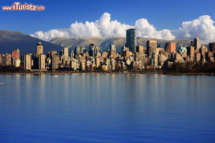 Immagine Il centro di Vancouver (Canada) coi suoi grattacieli, il mare e le montagne sullo sfondo in una giornata di sole. Dopo New York e San Francisco, Vancouver è la terza città del Nord America più sviluppata in verticale... e pensare che fino a pochi anni fa c'erano pochissimi grattacieli: la maggior parte di quelli che vediamo oggi sono spuntati tra il 1997 e il 2004, grazie all'arrivo in città di stranieri facoltosi - © Hannamariah / Shutterstock.com