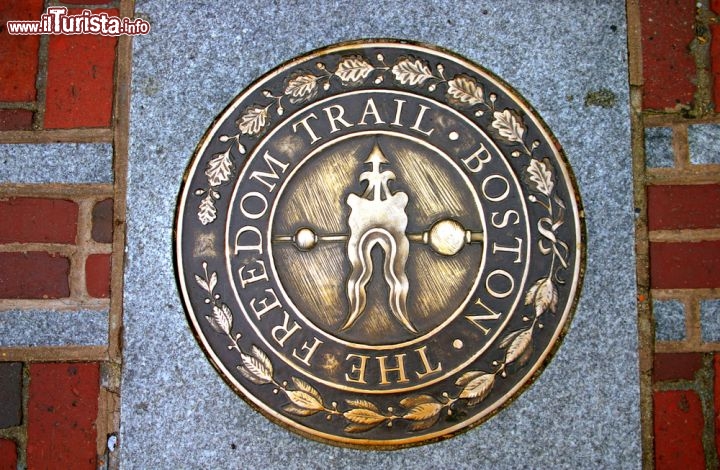 Immagine Il simbolo del Freedom Trail di Boston, itinerario turistico di 4 km che si snoda per le vie della città, segnalato da una doppia fila di mattoni rossi, collegando i 16 siti storici coloniali più importanti. Parte dal centro visitatori del Boston Common e termina a Charlestown, e i visitatori possono percorrerlo autonomamente o con una guida - © col / Shutterstock.com