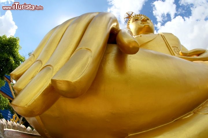 Immagine Particolare del Grande Buddha a Ubon Ratchathani, Thailandia - Estremamente piccole - come quella alta appena 7 cm che si trova all'interno del Wat Si Ubon Rattanaram - o di grandi dimensioni, le statue del Buddha realizzate dagli artigiani thailandesi sono la testimonianza di fede del popolo nei confronti di quella che viene considerata la figura spirituale più illustre del buddhismo. In questa suggestiva immagine, un particolare della mano del Grande Buddha rivestita, come tutto il corpo, da una sottile lamina dorata © KiddaiKiddee Studio / Shutterstock.com