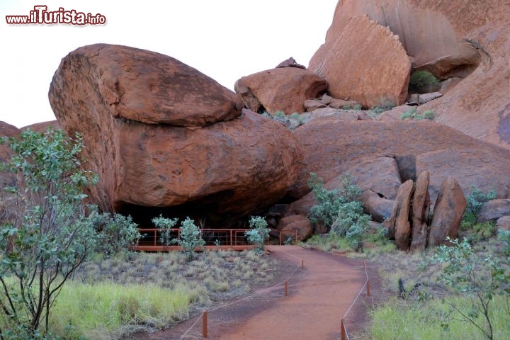 Immagine Una Grotta utilizzata dagli aborigeni a Ayers Rock (Australia) - Uluru è importantissima nella cultura aborigena, per il suo valore simbolico ed anche per le sorgenti che si trovano alla sua base; la ricchezza dell'acqua è fondamentale per la sopravvivenza nel deserto! Negli anfratti principali della montagna si trovano anche dipinti ed incisioni rupestri, e ancora oggi l'arte è il modo più ricco con cui la cultura aborigena riesce ad esprimersi