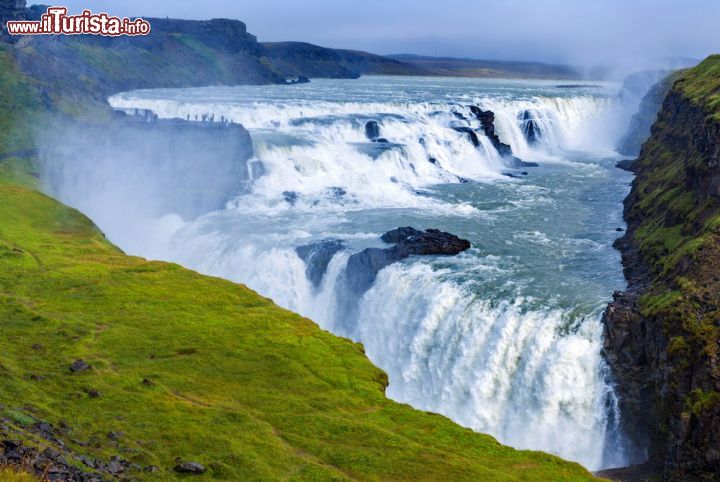 Immagine La cascata Gullfoss, Islanda. E' sicuramente una delle più famose dell'Islanda. Gullfoss, il cui nome islandese significa cascata dorata, si trova nella parte sud occidentale del paese, lungo il corso del fiume Hvita. Ha una portata di circa 140 metri cubi al secondo in estate e di 80 in inverno ed è caratterizzata da due salti di 11 e 21 metri di altezza. E' fra le attrazioni naturalistiche più note e visitate d'Islanda: grazie ad una serie di sentieri può essere raggiunta in tutta sicurezza sia nella parte superiore che in quella frontale - © Max Topchii / Shutterstock.com