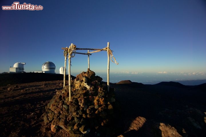 Immagine Isola di Hawaii, cima del vulcano Mauna Kea: il contrasto tra l'arcaico e il moderno. In primo piano un tipico Heiau, tempio sacro hawaiano. Templi come questo potevano essere costruiti per vari scopi: ingraziarsi le divinità affinché guarissero i malati, facessero cessare o aumentare le piogge, stabilissero la pace o favorissero la vittoria in guerra. Sullo sfondo i telescopi astronomici dell'Osservatorio di Mauna Kea - © Bivb / www.hvcb.org