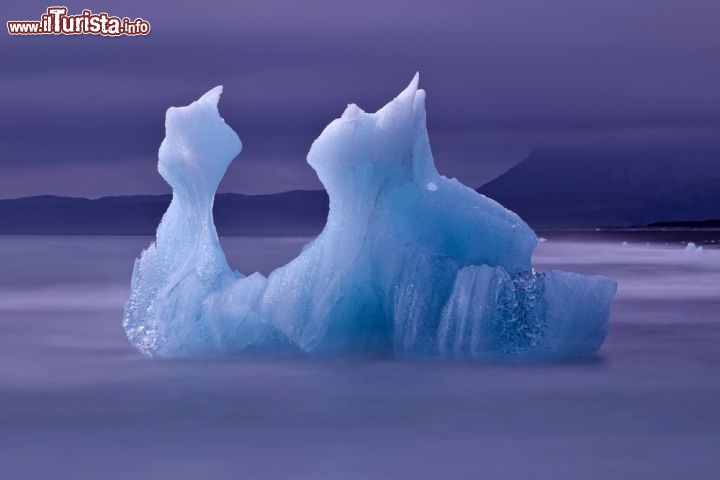 Immagine Un Iceberg nel lago Jokulsarlon, in Islanda. Si tratta del lago che si forma sul fronte del ghiacciaio  Vatnajokull, il vulcano più alto ed imponente d'Islanda che è ricoperto dalla più vasta calotta glaciale d'Europa. La laguna che si forma con le acque di fusione del ghiacciaio è sempre costellata da iceberg dalle forme più bizzarre e dalle tonalità più strane, a seconda del tipo di luce dell'ambiente - © stjepann / Shutterstock.com