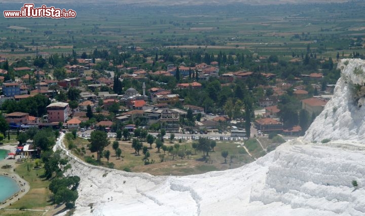 Immagine Il contrasto tra i calcari termali di Pamukkale e il villaggio moderno della pianura nell'ovest della Turchia. Tradotto in italiano il nome Pamukkale suonerebbe come "Castello di Cotone" e si tratta di depositi ci gesso, travertino e calcare lasciati dalle acque che sgorgano da 17 sorgenti termali, con temperature comprese tra i 35 ed i 100 gradi centigradi - © Ulysses_ua / Shutterstock.com