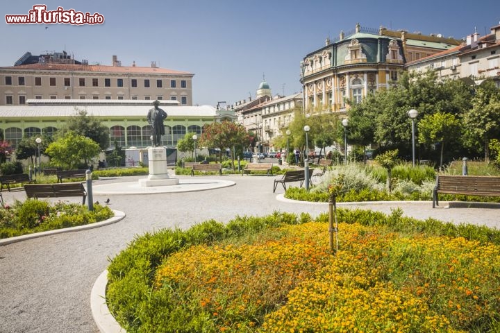 Immagine Il parco Kazalisni a Fiume, Croazia - Rimesso a nuovo nel 2005, il parco Kazalisni di Fiume è stato caratterizzato da un'attenta ristrutturazione che lo ha trasformato in una delle aree verdi più piacevoli della città croata. Le aiuole fiorite, gli alberi e i sentieri rendono questo spazio decisamente piacevole per una visita o una sosta. Proprio di fronte al teatro è stata collocata la fontana ideata dallo scultore Dusan Dzamonja mentre al centro del parco si trova la statua che ritrae il compositore Zajca a cui è stato intitolato il teatro stesso © Anilah / Shutterstock.com