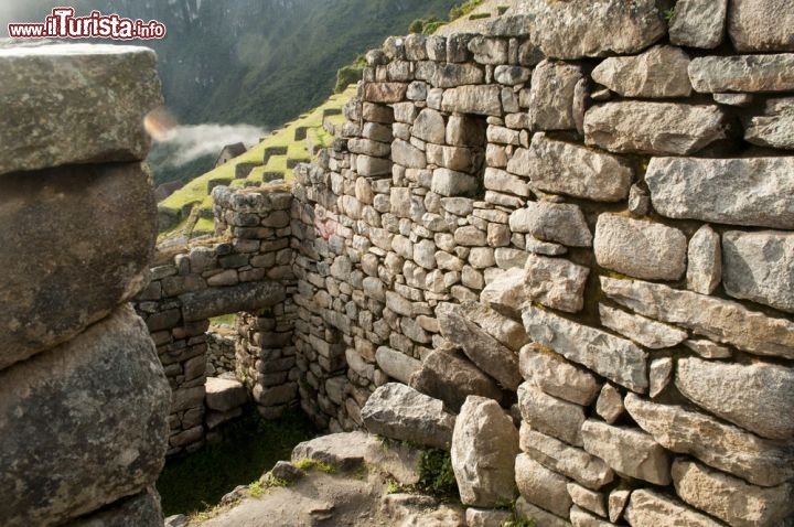 Immagine Impressionanti mura di Machu Picchu, Perù - Una città di pietra costruita in cima ad un istmo fra due montagne, una vera e propria sfida ingegneristica: secondo gli studiosi a decretare il segreto di longevità di Machu Picchu è stato il suo sistema di drenaggio formato da una copertura di pietre triturate e rocce per evitare proprio il ristagno dell'acqua. Le possenti mura e i quasi 130 canali di drenaggio contribuirono a fare entrare nella leggenda questa antica cittadella - © Aimee McLachlan / Shutterstock.com