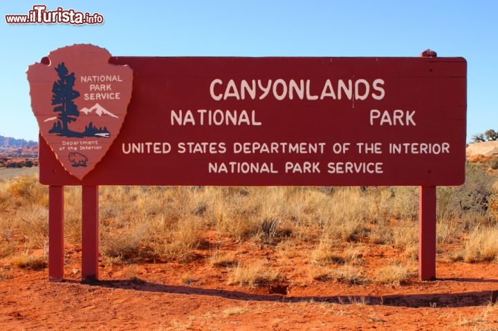 Immagine Benvenuti al Canyonlands National Park! Questo è il cartello che nello Utah, USA, accoglie i visitatori all'ingresso dell'area protetta istituita nel 1964, che si estende per 1366 kmq ed è attraversata dai profondi canyon scavati dal Colorado e dal Green River. Il paesaggio è semi-desertico, caratterizzato dal rosso e arancio della roccia e da panorami vertiginosi - © Jason Patrick Ross / Shutterstock.com