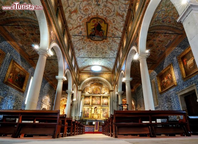 Immagine Interno della chiesa di Santa Maria a Obidos, Portogallo - In Praca de Santa Maria si trova l'omonima chiesa caratterizzata da una bella torre campanaria e da un portale in stile rinascimentale. All'epoca in cui i Mori erano signori di questo territorio, qui doveva sorgere una moschea poi trasformata in luogo di culto cristiano quando nel 1148 Obidos venne conquistata da Alfonso Henriques. L'interno della chiesa ha pareti rivestite dal basso all'alto con decorazioni a azulejos di epoca settecentesca oltre a un bel soffitto in legno che assieme creano un gradevole effetto decorativo. Fra i capolavori ospitati in questo edificio vi sono il sepolcro rinascimentale di Joao de Noronha e un dipinto di Josefa da Obidos che unsice sacro e profano © Emi Cristea / Shutterstock.com