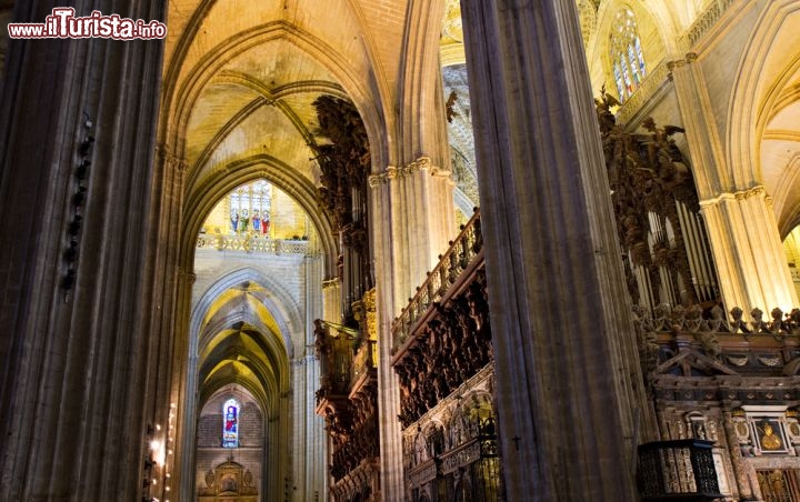 Immagine L'interno della Cattedrale di Siviglia è a cinque navate, in stile gotico, e le belle vetrate che filtrano la luce esterna creano un'atmosfera di intimità e raccoglimento nella penombra. Le varie sezioni della chiesa (navata di re Ferdinando III, crociera e trascoro) rappresentano le classi sociali medievali dei nobili, degli ecclesiastici e del popolo - © Circumnavigation / Shutterstock.com