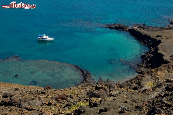 Immagine Le acque azzurro turchese dell'Oceano Pacifico lambiscono i crateri vulcanici che caratterizzano l'isola ecuadoregna di Bartolomé, una delle tante che formano l'arcipelago delle Galapagos un tempo conosciute anche come "Las Islas Encantadas" per via della difficoltà di navigazione dovuta alle forti correnti marine - © Peter Sobolev / Shutterstock.com