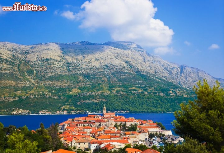 Immagine Il clima dell'isola di Korcula (Croazia), risente delle montagne della penisola di Peljesac, che come si vede dalla foto, fungono da barriera orografica che protegge l'isola dai venti di bora e tramontana. Per questo motivo a Korciula non fa mai freddo in inverno, e le piogge abbondanti autunnali garantiscono una vegetazione rigogliosa, anche durante la bella stagione, quando l'isola di Curzola diventa una delle principali attrazioni del mare della Dalmazia - ©Tatiana Popova / Shutterstock.com