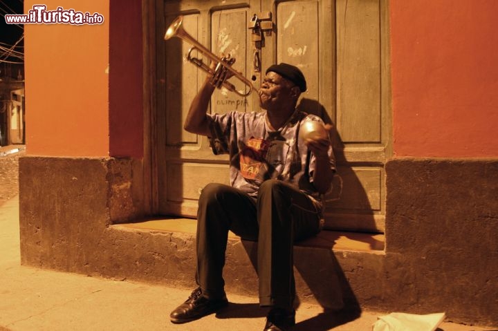 Immagine Suonatore di tromba, New Orleans - Considerata da sempre la culla del jazz, sin dal 1800 New Orleans fu un importante crocevia di musiche, danze e canti di diversa provenienza portate sin qui da schiavi, mulatti, neri liberi e bianchi. Con il passare del tempo nella città della Louisiana si venne a creare una fusione fra la musica urbana scritta, quella di bande e pianisti, e quella contadina orale, ovvero il blues, che diede presto vita ad una forma musicale conosciuta con il nome di jazz. In questa immagine, un suonatore di colore mentre rallegra una via di un quartiere di New Orleans con note e melodie della sua tromba - © Shawn Talbot / Shutterstock.com