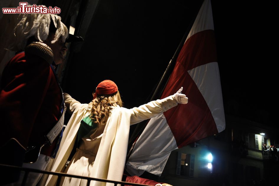Immagine La mugnaia si affaccia dal balcone per la prima volta, carnevale di Ivrea, Piemonte. Assieme a lei sarà il generale ad accompagnarla nel vivo della rassegna storica - © www.storicocarnevaleivrea.it