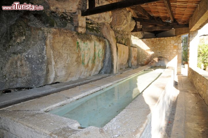 Immagine Lavatoio a Tourrettes sur Loup, Francia - Addossato ad una grotta scavata nella roccia, lungo l'arteria principale del paese, si trova un lavatoio che risale al 1900 alimentato dall'acqua che proviene da una sorgente: la pietra del bordo, in alcuni punti particolarmente consumata, indica l'utilizzo quotidiano che un tempo le donne di Tourrettes e delle borgate vicine facevano di questa preziosa costruzione © Sonja Vietto Ramus