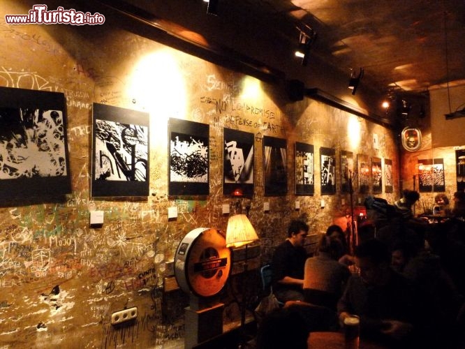 Immagine Locale Szimpla Kert in via Kazinczy a Budapest, Ungheria - Non solo è considerato il miglior bar fra le rovine di Budapest ma addirittura uno dei best 100 al mondo. Il Szimpla Kert nasce nel 2002 su immagine e somiglianza del primo Szimpla, caffetteria che ha dato origine ai famosi Romcoksa di Budapest. Il Kert, creato all'interno di una fabbrica abbandonata nei pressi dell'Università, è uno dei locali più frequentati da ungheresi e turisti. Vi si può bere una birra, ballare, assistere ad un concerto e se si è artisti anche esporre le proprie opere negli appositi open space messi a disposizione dai proprietari. E' aperto dalle 12 alle 2 di notte tutti i giorni. Il bar si sviluppa su due piani molto ampi e ha stanze arredate in maniera differente l'una dall'altra.