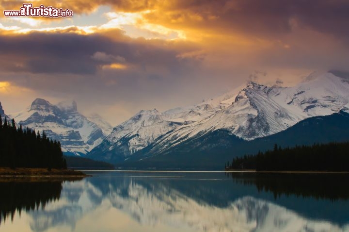 Immagine Il Maligne Lake all'interno del Jasper National Park (Canada) reso ancora più affascinante dalle montagne innevate e da un cielo plumbeo screziato di sole - © BGSmith / Shutterstock.com