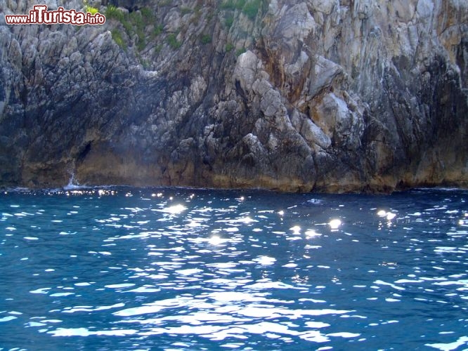 Immagine Il mare luccicante a fianco delle rocce calcaree di Capo Palinuro: lungo queste rocce a picco sul Tirreno, vero paradiso per i subacquei, si aprono numerose grotte e cavità carsiche - © alphaspirit / Shutterstock.com