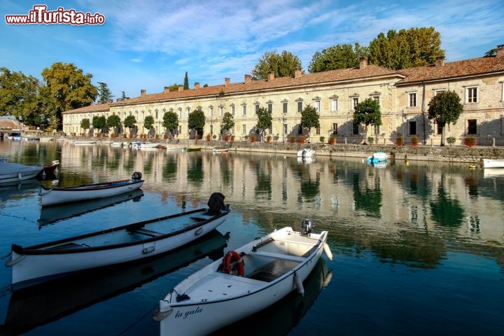 Immagine Foto panoramica della marina di Peschiera, non lontano da Desenzano del Garda - Conosciuto anche come porto vecchio, anche il porticciolo di Desenzano è una delle location da non perdere quando si visita la città. Durante il dominio veneziano di questo territorio, il porto fu particolarmente attivo in quanto utilizzato per i consistenti e frequenti commerci del grano. Ad affacciarsi sulle acque del Lago sono il molo costruito nel 1806, il faro e il ponte in stile veneziano che si fanno risalire agli anni Trenta del Novecento © Philip Bird LRPS CPAGB / Shutterstock.com