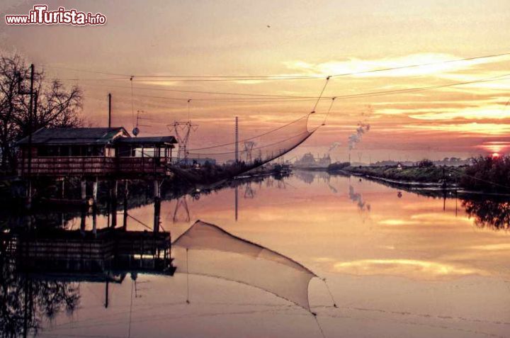 Immagine Il canale degli staggi a Marina Romea al tramonto, con un "padellone" in primo piano cioè uno dei locali capanni da pesca - ©  Enrico Strocchi - CC BY-SA 2.0 - Wikipedia