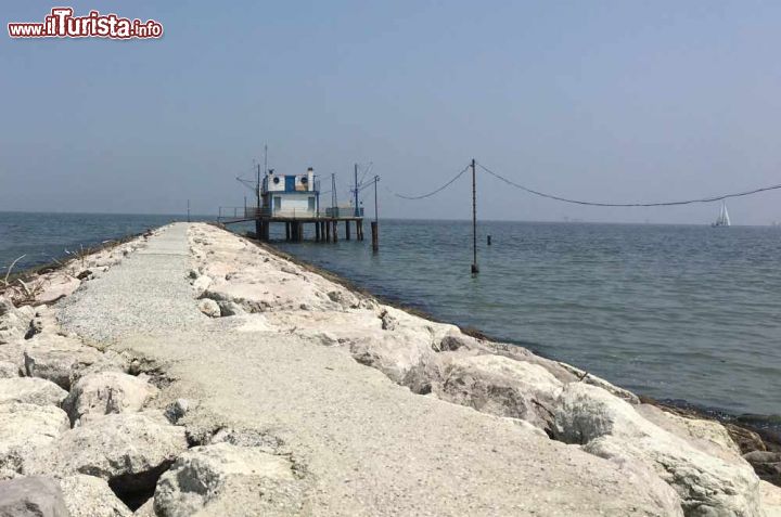 Immagine La foce del fiume lamone a Marina Romea: Chiude a nord la spiaggia, con un argine con blocchi di calcare e un capanno da pesca - © Lorenzov79 - CC BY-SA 4.0 - Wikipedia