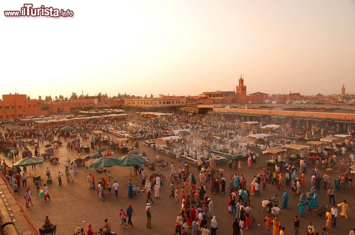 Immagine Tramonto sulla piazza Jamaa el Fna di Marrakech, Marocco - Le luci del tramonto rendono ancora più affascinante questa piazza di forma irregolare che cambia aspetto durante la giornata: di mattina e pomeriggio ospita un vasto mercato all'aperto con bancarelle che vendono le merci più svariate mentre di sera diventa un ristorante dove assaporare deliziosi cibi preparati sul momento