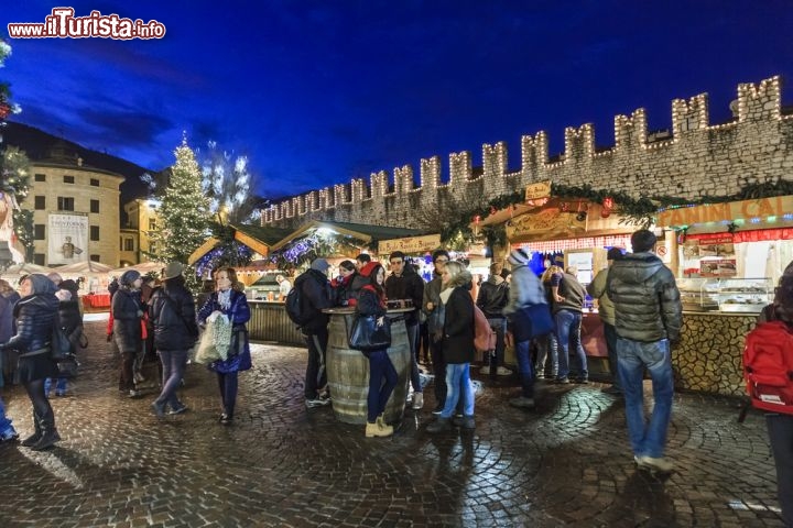 Immagine Mercatini di Natale in Piazza Fiera, Trento - Addobbi per l'albero di Natale, oggetti d'artigianato e squisite specialità gastronomiche locali per vivere l'atmosfera natalizia. I mercatini di Piazza Fiera, nel cuore di Trento, ospitano da sempre le tradizionali casette in legno dove turisti provenienti da tutt'Italia ed Europa si recano in visita ogni anno per immergersi fra sapori e colori delle festività © Orietta Gaspari / Shutterstock.com