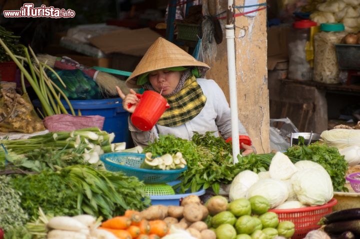 Immagine il colorato mercato di Phu Quoc, Vietnam: una bancarella che vende verdura, e un venditore che si rinfresca con un succo - © Patrik Dietrich / Shutterstock.com