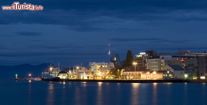 Immagine Scorcio notturno su Molde, Norvegia - Situata sulla sponda settentrionale di un fiordo bagnato dal Mare di Norvegia, Molde è una cittadina della contea di More og Romsdal conosciuta anche come "città delle rose" poichè grazie al clima mite vi crescono rose e altre piante che, normalmente, alla stessa latitudine non sono presenti nella flora locale. In questa immagine, un suggestivo panorama notturno di questa località norvegese che si riflette sulle acque del mare © Robert Cumming / Shutterstock.com