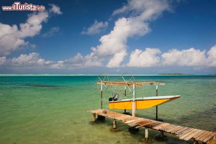 Immagine Isola di Maupiti, arcipelago delle Isole della Società, Polinesia Francese: una piccola barca ormeggiata al molo di legno, nel turchese dell'Oceano Pacifico, forse pronta per andare a pescare... la pesca, insieme al turismo e alla coltivazione del noni (o gelso indiano), è la risorsa economica principale dell'isola - © Piotr Gatlik / Shutterstock.com