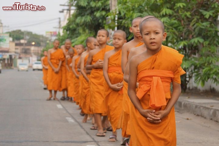 Immagine Monaci del tempio Wat Thung Si Meuang, Ubon Ratchathani - Ogni giorno, con indosso la loro tunica arancione, i giovani monaci escono dal monastero Wat Thung Si Meuang, edificato durante il regno di Rama III e sempre aperto al pubblico. In fila indiana si recano nel centro di Ubon per ricevere dagli abitanti offerte di riso, frutta e fiori, azioni che permettono ai buddhisti di guadagnarsi i meriti per la vita successiva © wk1003mike / Shutterstock.com