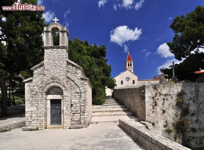 Immagine Monastero di Bol sull'Isola di Brac in Croazia: la cappella Sant Ivano e Teodoro, la chiesa del 1475 sullo sfondo - © Mirvav / Shutterstock.com