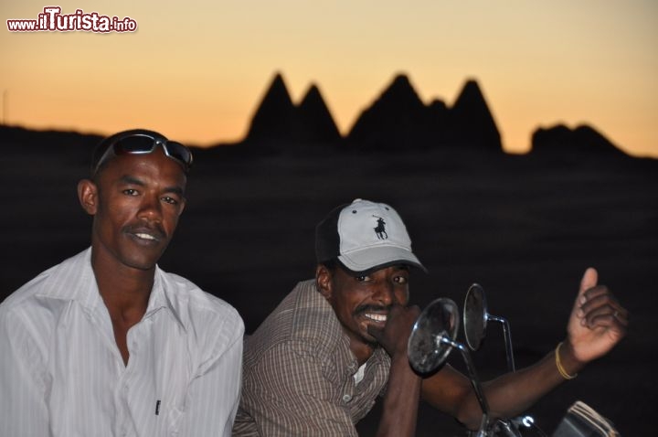 Immagine Motociclisti sudanesi al tramonto al Gebel Barkal a Karima. Sullo sfondo le piramidi