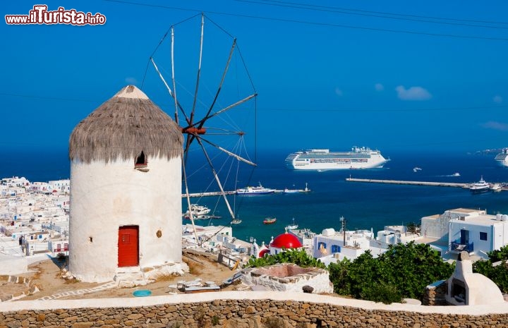 Immagine Mulino a vento sopra il porto vecchio di Mykonos. Sullo sfondo una nave da crociera alle, Cicladi nela mare Egeo della Grecia - © Natalia Dobryanskaya / Shutterstock.com