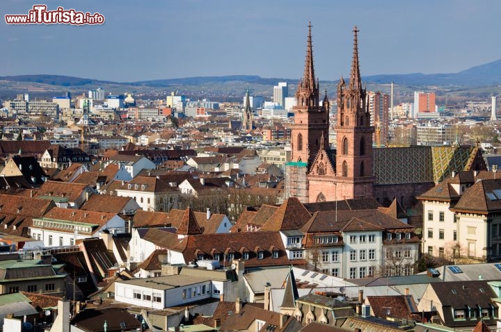 Immagine La Cattedrale nel centro di Basilea - Ritenuta uno degli edifici più suggestivi e importanti della città, la Cattedrale gotica si affaccia su via Heuberg, una delle strade più belle di tutto il centro storico di Basilea. La chiesa si innalza imponente e maestosa fra vecchi palazzi e dimore nel cuore di Basel come si osserva in questa immagine fotografica scattata dall'alto che ne evidenzia le guglie e le decorazioni del tetto © Matteo Cozzi / shutterstock.com