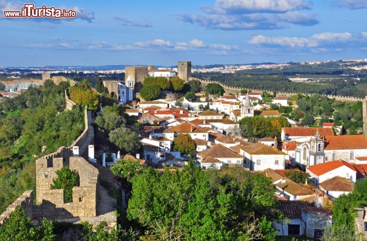 Immagine Panorama sulle mura del borgo di Obidos, Portogallo - Osservato dall'alto, l'antico borgo portoghese, racchiuso fra le sue imponenti e massicce mura fortificate, è ancora più suggestivo. Le numerose porte d'accesso dislocate lungo le mura merlettate sono anche una bella testomonianza artisticaper via delle variopinte decorazioni con azulejos © Arseniy Krasnevsky / Shutterstock.com