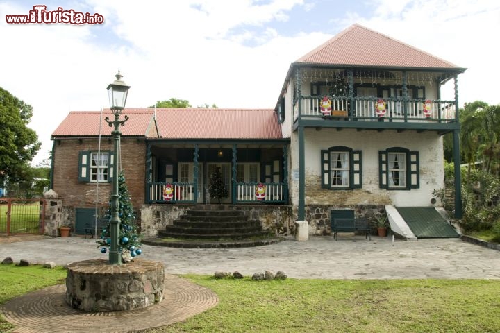 Immagine Il museo storico di Sint Eustatius ad Oranjestad, capitale dei Caraibi Olandesi - Essendo la località così particolare e singolare, nel 1974 è nata l'idea di creare una fondazione che potesse racchiuderne l'essenza. Il risultato è visibile nel polo museale che vive grazie a diversi Enti e Organizzazioni specializzate nel campo dei monumenti e dell'archeologia. Si può osservare l'artigianato locale, la cultura e la storia di Oranjestad e delle sue località, diversi documenti nonché splendide ceramiche. Il tutto, come si può vedere dall'immagine, contornato da un edificio tiepido, dove l'arte che riflette è altrettanto semplice e non ha pretese diverse - © rj lerich / Shutterstock.com
