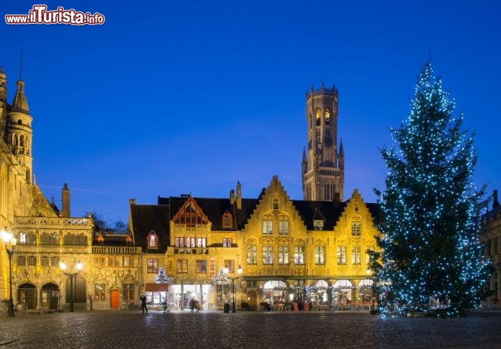 Immagine Natale a Bruges, Belgio - Non esistono tante altre scenografie medievali come quella di Bruges adatte ad ospitare il Natale e la sua atmosfera. Le strade lastricate, gli edifici antichi e i cavalli che trainano i calessi offrono a visitatori e turisti uno scenario incantevole che li accompagna alla scoperta di questa bella città delle Fiandre. Protagonista assoluto è il mercatino di Natale con le sue illuminazioni e le dolci bontà che si possono acquistare, assieme a molti altri oggetti dell'artigianato locale, sulle bancarelle ospitate nelle piazze di Markt e Simon Stevin © Nejron Photo / Shutterstock.com