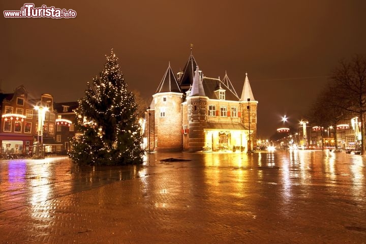 Immagine Fotografia notturna del Nieuwmarkt, Amsterdam - Piazza e quartiere della capitale olandese, in questa zona risiede una grande minoranza cinese tanto che i segnali sono scritti sia in olandese che in lingua cinese. Vi si svolgono mercatini di antiquariato, cibi biologici e altri prodotti oltre che essere sede di varie fiere ed eventi. In questa immagine è ritratta di sera illuminata dalle luminarie allestite per i festeggiamenti di Natale Foto di nilayaji / Bigstockphoto