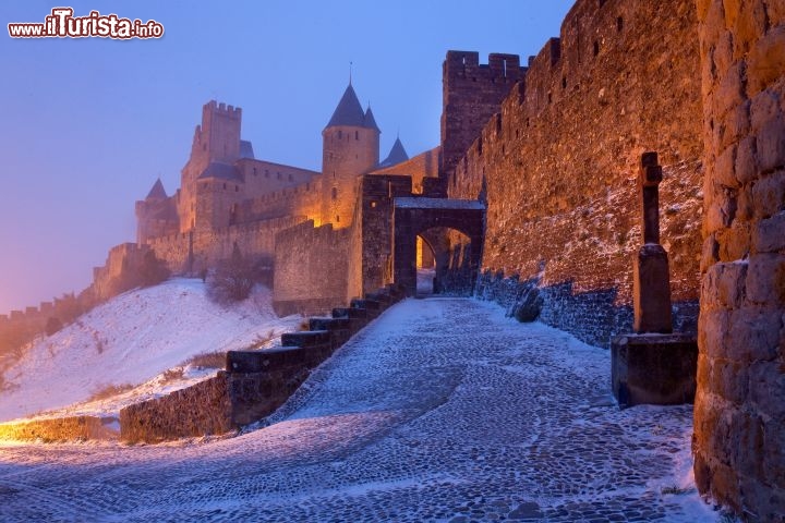 Immagine Neve a Carcassonne, lungo le mura del borgo medievale francese. La struttura difensiva, lunga un paio di chilometri e dotata di una sessantina di torri, comprende la Porta Narbonnaise realizzata nel XIII secolo e il Castello di Comtal del XII secolo, a sua volta composto da appartamenti di corte, una basilica, una chiesa e ben 38 torri - © Paul Palau