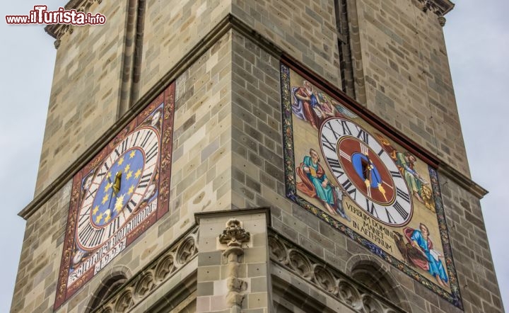 Immagine Orologio della Chiesa Nera di Brasov, Romania - Biserica Neagra, ovvero Chiesa Nera, è da sempre il simbolo più conosciuto della città di Brasov oltre che la più grande chiesa gotica dell'intera penisola balcanica. Venne edificata tra il 1383 e il 1480 e deve il suo nome ad un terribile incendio che scoppiò nel 1689 e che danneggiò l'edificio religioso. Grazie a recenti restauri, la chiesa è tornata al suo antico splendore anche se i segni provocati da questo episodio si intravedono tutt'oggi sotto a molte statue con cui è decorata. Oltre ad un centinaio di tappeti turchi e a un organo con 4000 canne, Biserica Neagra vanta un bellissimo orologio affrescato, con decorazioni differenti, sulle 4 facciate della torre © Marc Venema / Shutterstock.com