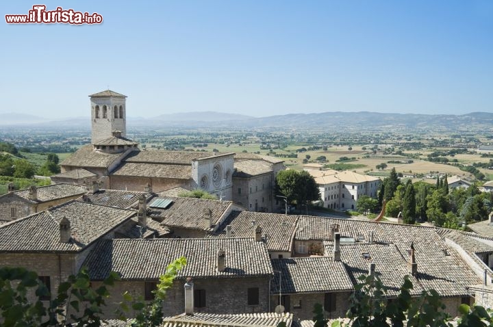 Immagine Panorama su Assisi e sulla Chiesa di San Pietro. Fondata assieme al monastero nel X° secolo dai benedettini del monte Subasio, l'edificio religioso dedicato a San Pietro venne ricostruito agli inizi del 1200 assumendo le attuali forme romanico-gotiche. A consacrarla fu papa Innocenzo IV° nel 1253 - © Mi.Ti. / Shutterstock.com