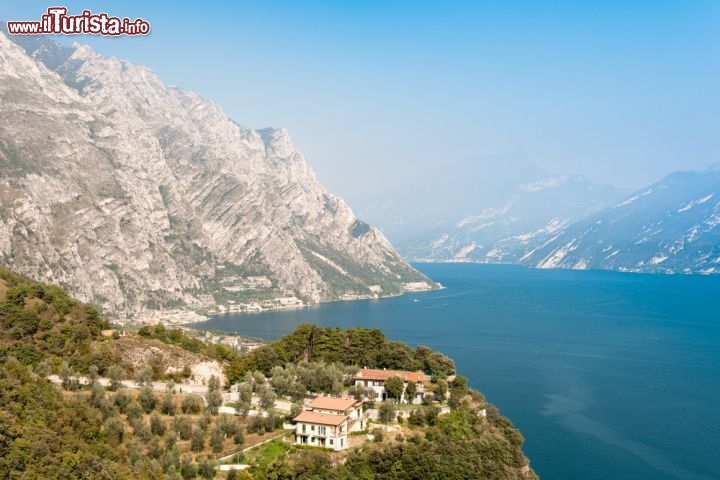 Immagine Fotografia panoramica del Lago di Garda, Limone - La roccia delle montagne che sembra tuffarsi nelle acque del più grande lago d'Italia incontra i boschi verdeggianti che circondano il borgo di Limone creando un incredibile contrasto naturale. Per chi si avventura alla scoperta di questo territorio ospitato in provincia di Brescia non c'è solo natura ma anche storia, cultura e religione grazie ai tanti monumenti e edifici religiosi da visitare © Jules_Kitano / Shutterstock.com