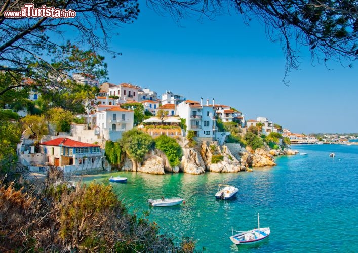 Immagine Panorama della città vecchia skiathos , con le sue catatteristiche casette che s'affacciano su di un mare cristallino. Siamo nelle isole Sporadi settentrionali e Skiathos è una ambita meta turistica per le sue numerose spiagge, e anche per la cornice di verde ricca di pini e macchia mediterranea, una delle isole della Grecia più famose - © Nikos Psychogios / Shutterstock.com