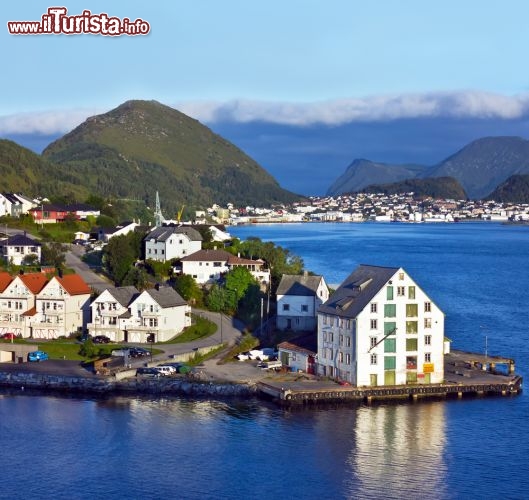 Immagine Panorama del fiordo di Alesund, nella regione del Sunnmøre, Norvegia occidentale. Le attrazioni più belle della città sono rappresentate dai tre punti panoramici che la circondano - il monte Aksla, Fjellstua e Kniven - da cui si apprezzano le sagome delle montagne, i profili delle numerose isole, il blu della baia e i pittoreschi tetti delle case - © Vlada Zhykharieva / Shutterstock.com