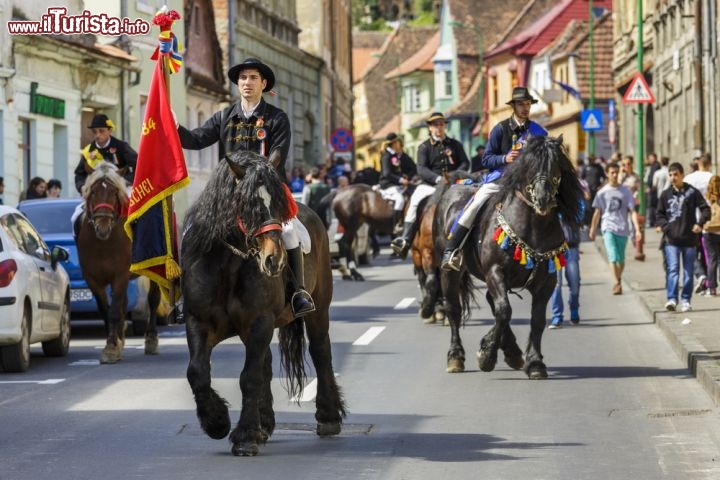 Immagine Juni Festival di Brasov, Romania - Si svolge ogni anno la domenica successiva la Pasqua ed è una tradizionale festa dove elementi magici e rituali si fondono fra di loro. E' lo Juni Festival di Brasov: gruppi di uomini a cavallo transitano per il centro della città sino a raggiungere la chiesa di San Nicola, disponendosi attorno alla statua del Milite Ignoto, sino all'arrivo del parroco che consacra e benedisce i partecipanti © Photosebia / Shutterstock.com