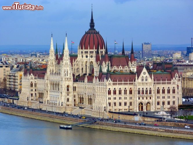 Immagine Parlamento Ungherese a Budapest, Ungheria - Simbolo della città oltre che una delle mete turistiche più importanti, il Parlamento di Budapest si trova sulla sponda del Danubio dalla parte di Pest. Concepito nell'Ottocento per sottolineare l'indipendenza degli ungheresi all'interno dell'impero austro ungarico, venne eretto tra il 1885 e il 1905 su disegno dell'architetto Imre Steindl. Lo stile architettonico è neogotico con sviluppo orizzontale: raggiunge i 268 metri di lunghezza e i 123 di larghezza mentre si eleva per 96 metri. Dispone di una decina di cortili e di una trentina di ingressi. Di particolare interesse è la cupola che si distingue per la forma esadecagono, struttura che si ripete anche in quella della sala centrale sottostante che ha funzioni rappresentative.