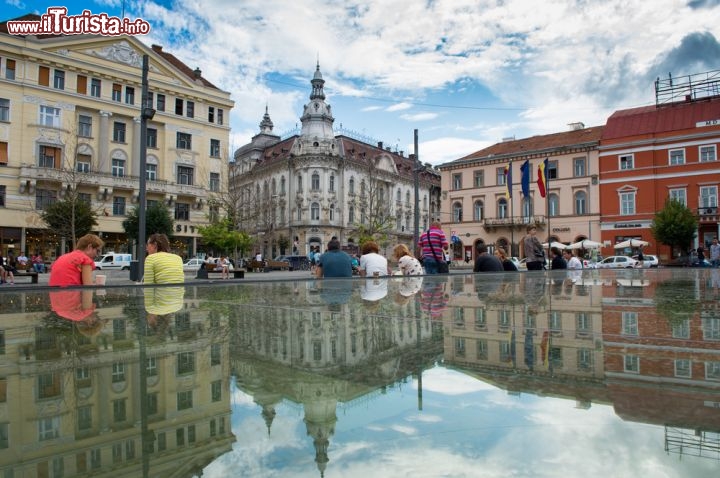 Immagine Piazza centrale di Cluj Napoca, Romania - L'attuale architettura della città ne testimonia il vivace passato tanto che dal X° secolo l'unico dato sempre certo fu la ricostruzione. La maggior parte degli edifici che non rispondevano più alle adeguate esigenze estetiche e di utilizzo delle nuove epoche venivano demoliti per lasciare spazio a nuove costruzioni, motivo per cui nel cuore della città si mescolano palazzi e monumenti con stili così differenti. Anche sulla piazza centrale di Cluj troviamo esempi di questa multietnica architettura © ldphotoro / Shutterstock.com