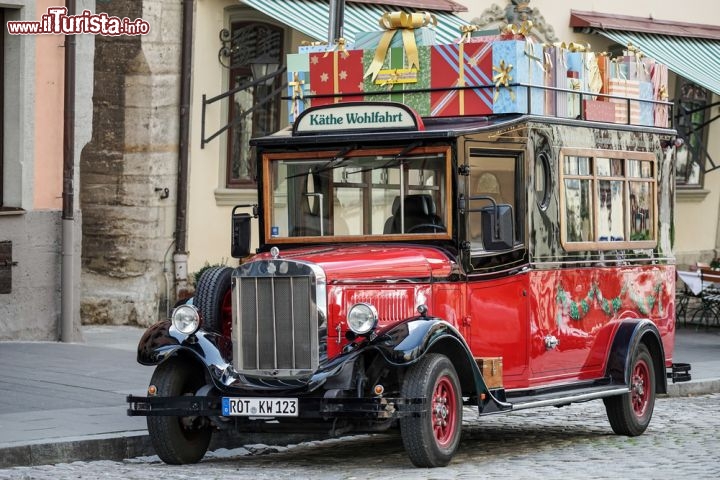 Immagine Auto del Kathe Wohlfahrt Store di Rothenburg, Germania  - Con i suoi colorati pacchi regalo sul portapacchi, questa caratteristica auto dalla livrea rosso fiammante accompagna alla scoperta degli oggetti natalizi esposti nel famoso villaggio di Natale di Kathe Wohlfarth Store di Rothenburg. Qui si trovano un'ampia scelta di oggetti, circa 30 mila, e una vasta collezione di decorazioni e luminarie oltre che oggetti pregiati realizzati in vetro, legno o stagno © Philip Bird LRPS CPAGB / Shutterstock.com